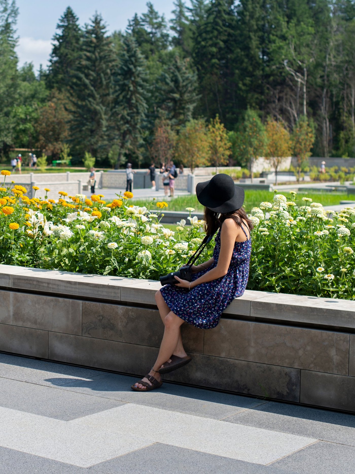 A visitor seated beside the marigold border at the Aga Khan Garden