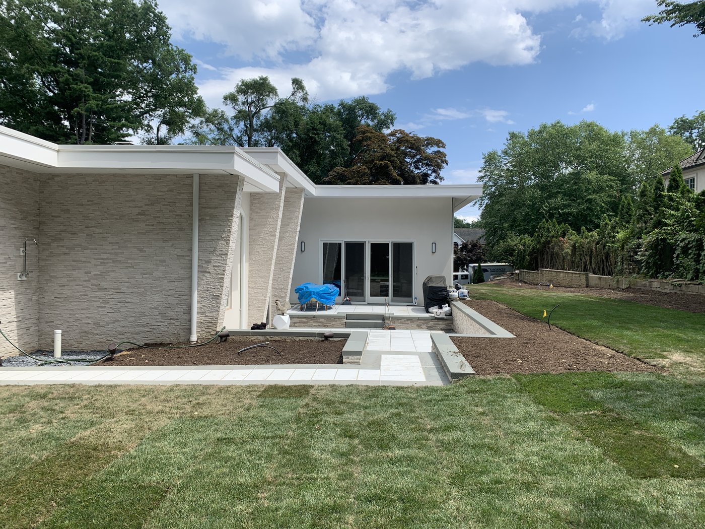 The property before — patio under construction, fresh sod